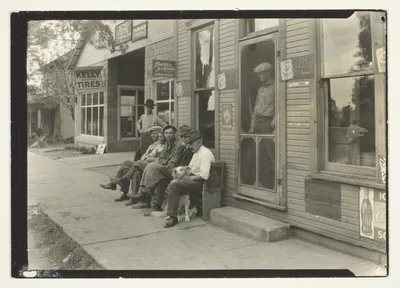 Men With Dog Sitting On Bench In Front Of General Store — Lewis Hine