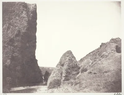 Ruisseau coulant entre une falaise et des rochers — Édouard Baldus